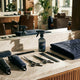 A professionally arranged barbershop station displaying branded tools, a folded cape, and grooming equipment in a cohesive dark color scheme under warm editorial lighting.