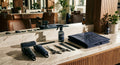 A professionally arranged barbershop station displaying branded tools, a folded cape, and grooming equipment in a cohesive dark color scheme under warm editorial lighting.